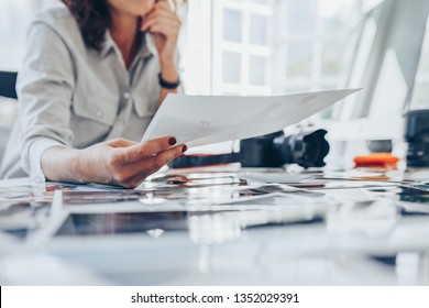 Woman busy working in her studio. Cropped shot of a female photographer checking prints after developing. - Powered by Shutterstock