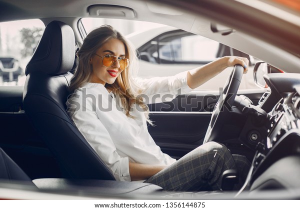 Woman buying the car.\
Lady in a car salon