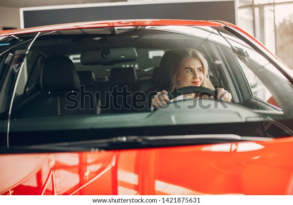 Woman buying the car.\
Lady in a car salon