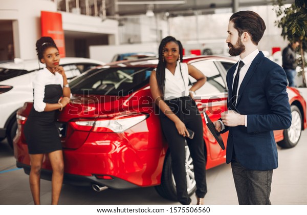 Woman buying the car. Lady in a car salon.\
Manager with a clients