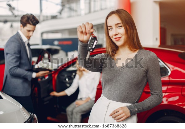 Woman buying the car. Lady in a car salon.\
Manager with a clients