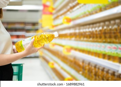 Woman Buying Cooking Oil In Supermarket