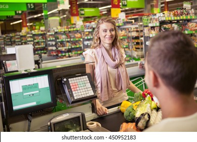 Woman Buying Food At Supermarket And Making Check Out With Cashdesk Worker In Store