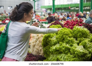 Woman Buying Fresh Vegetables On The Market