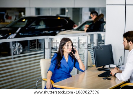 Woman buying a new car discussing on smartphone loan agreements terms