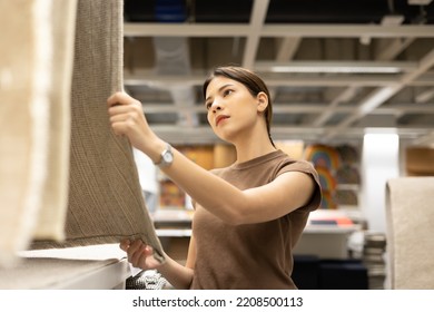 Woman Buying New Carpets For The House. Female Customer Shopping Carpet In Interior Store. Touching Testing Quality Of Product. Shopping Furniture At Warehouse Store Hall