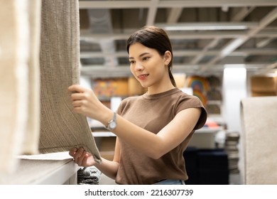 Woman Buying New Carpets For The House. Female Customer Shopping Carpet In Interior Store. Touching Testing Quality Of Product. Shopping Furniture At Warehouse Store Hall