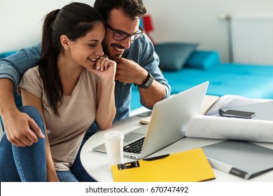 Woman Buying Online Stocks Actions.She Using Laptop While Her Husband Sitting Beside And Support Her.