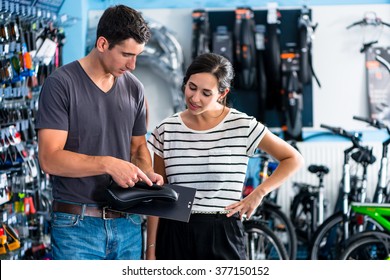 Woman buying parts in bike shop