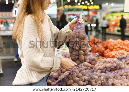 Woman buying potatoes in food store.