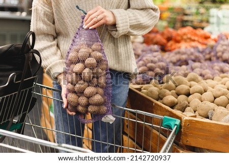 Woman buying potatoes in food store.