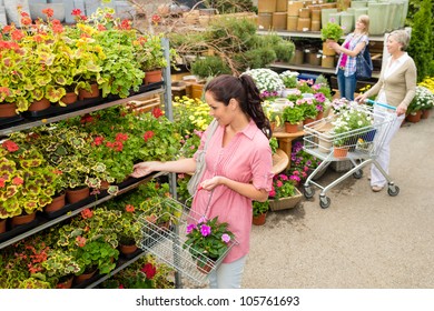 Woman Buying Potted Flower In Garden Center Shopping Basket Greenhouse