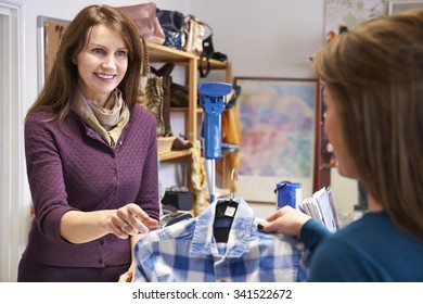 Woman Buying Shirt In Charity Shop