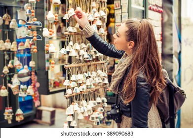Woman buying souvenirs. Young woman buying souvenirs in gift shop