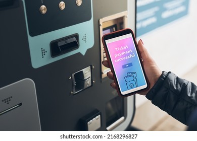 Woman buying ticket at ticket machine paying using mobile payment app on smartphone. Female buying bus public transport ticket in vending machine. Purchasing car parking ticket using mobile phone - Powered by Shutterstock