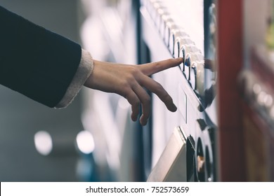 Woman buying with a vending machine