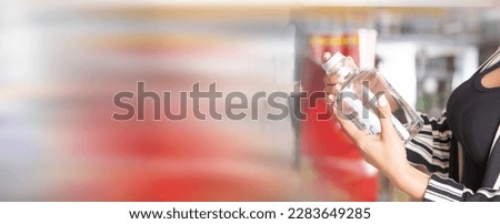 Woman buying vodka at supermarket.