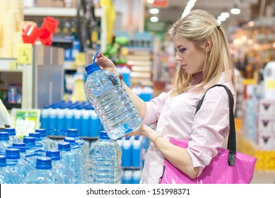 Woman Buys A Bottle Of Water In The Store