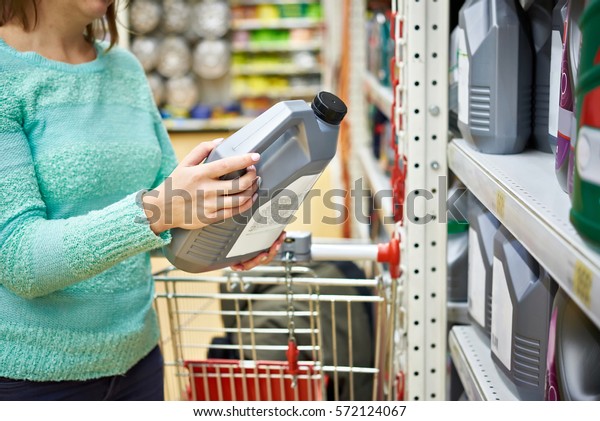 Woman buys engine oil\
in the supermarket