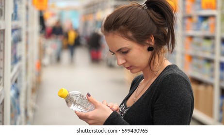 Woman Buys Mineral Water In Supermarket Or Store