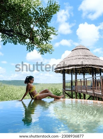  woman by the pool on a luxury safari, South Africa, a luxury safari lodge in the bush of a Game reserve