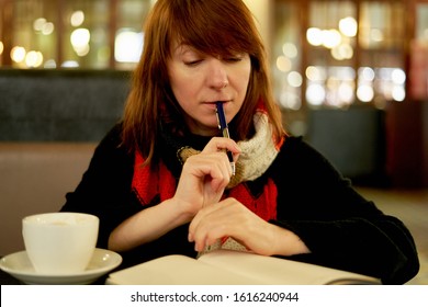 Woman in cafe writes in diary, bullet journal. Slow life, social detox, freelance, planning, self-immersion, being single concept. Middle-aged female think about morning pages in cafe - Powered by Shutterstock