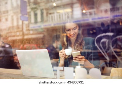 Woman at the cafeteria using technology
