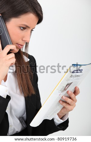 Woman calling an advert in a magazine