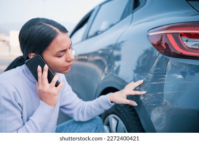 Woman calling car insurance examining car damage - Powered by Shutterstock