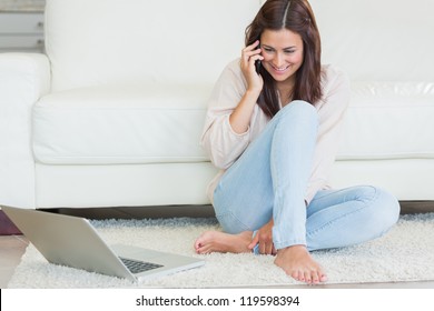 Woman calling in front of laptop on living room floor. Working from home in quarantine lockdown. Social distancing Self Isolation - Shutterstock ID 119598394