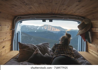Woman in a camper van enjoying the mountain view.