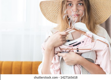 Woman Can Not Choose Which Clothes Pack For Travel. Clothing, Fashion, Style And People Concept - Woman Choosing Clothes At Home Wardrobe. 