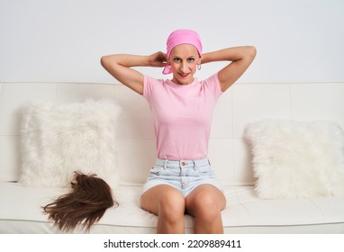 A Woman With Cancer Has Taken Off Her Wig And Is Wearing A Pink Scarf