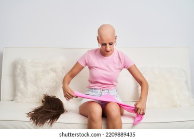 A Woman With Cancer Has Taken Off Her Wig And Is Wearing A Pink Scarf