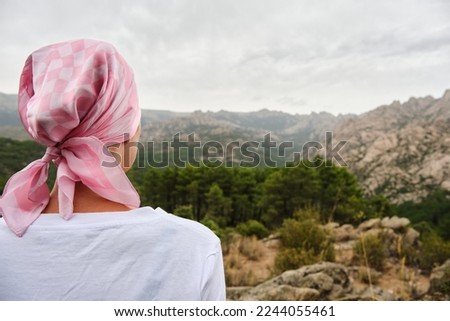 Woman with cancer meditating on her illness in nature.