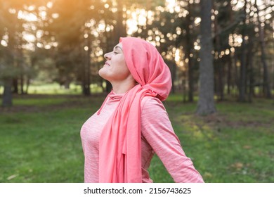 woman with cancer in nature while breathing fresh air, concept of a woman fighting cancer, woman with pink scarf relaxed. - Shutterstock ID 2156743625