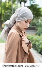 Woman Cancer Patient Having Pain With Treatment Adverse Effect, Wearing Head Scarf Due To Post Chemotherapy Hair Loss And Painful Radiation Therapy Side Effect
