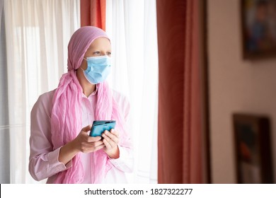Woman With Cancer, Pink Headscarf And Mask Typing Message On Mobile Phone
