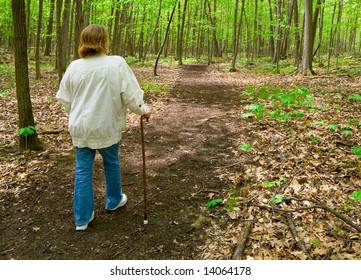 Woman With Cane Walking In The Woods