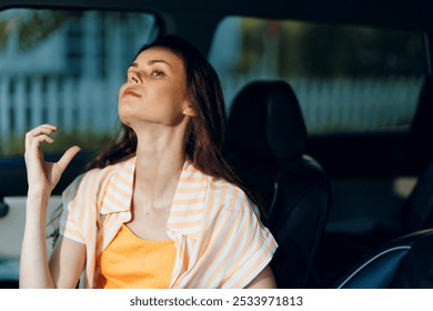 Woman in a car applying perfume, bright outfit with orange top and striped shirt, soft natural light, intimate and personal moment of self care and confidence - Powered by Shutterstock