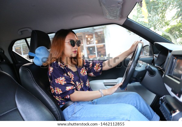 woman car\
asian driver on the road using\
sunglasses