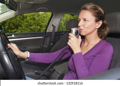 Woman In Car Blowing Into Breathalyzer