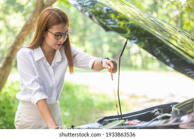 A Woman In A Car Broke Down On The Road Trying To Fix The Problem And Called A Car Repair Shop Or Someone Close To Help.