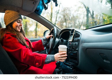 Woman In Car With Cup Of Coffee In Autumn Day