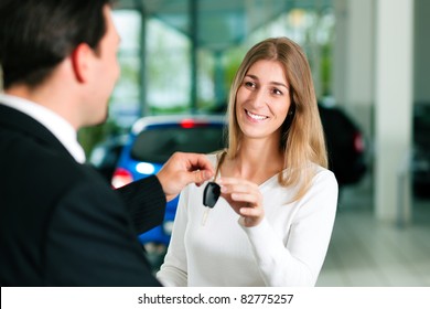 Woman At A Car Dealership Buying An Auto, The Sales Rep Giving Her The Key