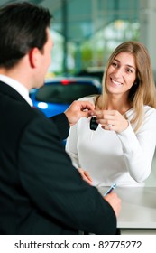 Woman At A Car Dealership Buying An Auto, The Sales Rep Giving Her The Key