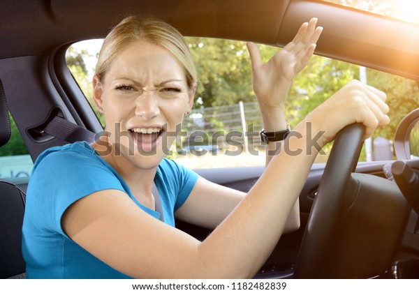 Woman as a car driver is in stress and scolds of\
annoyance during the car\
ride