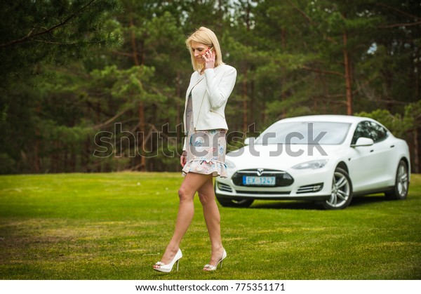 Woman and car or car and woman The future\
car, Tesla Model S 90D and the owner of a young business woman.\
/Description- Riga, Latvia, April 10, 2017 year\
