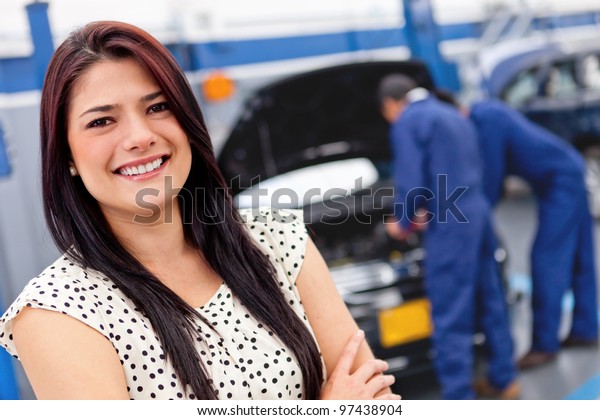 Woman at a car\
garage getting mechanical\
service