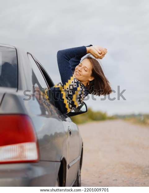 woman in a car is going on a road\
trip. a happy female traveler and labrador retriever looks out the\
car window. have fun. freedom and joy for a single\
woman